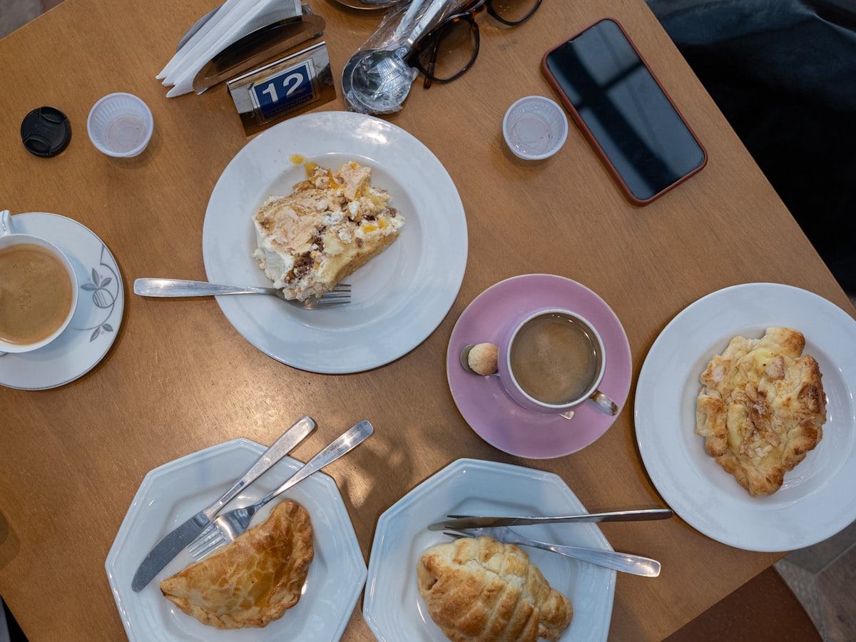 Gedeckter Cafétisch von oben mit zwei Kaffeetassen, Strudel und Plundergebäck