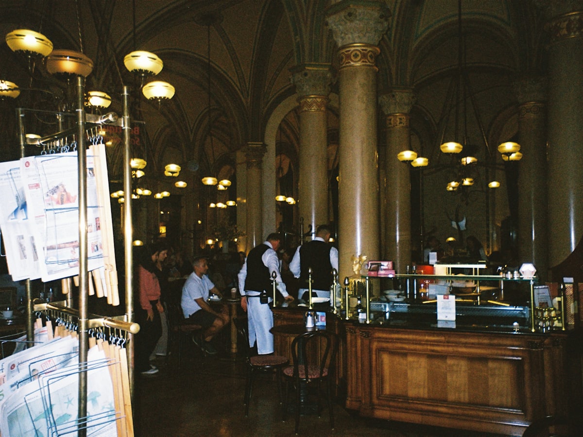Kaffeehaussaal mit Säulen, Kugelleuchten und Thonet-Stühlen in der Wiener Tradition